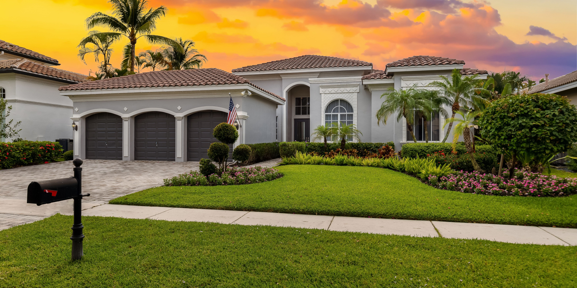 A beautiful Florida home is shown with a new shingle roof with the sun setting in the background.